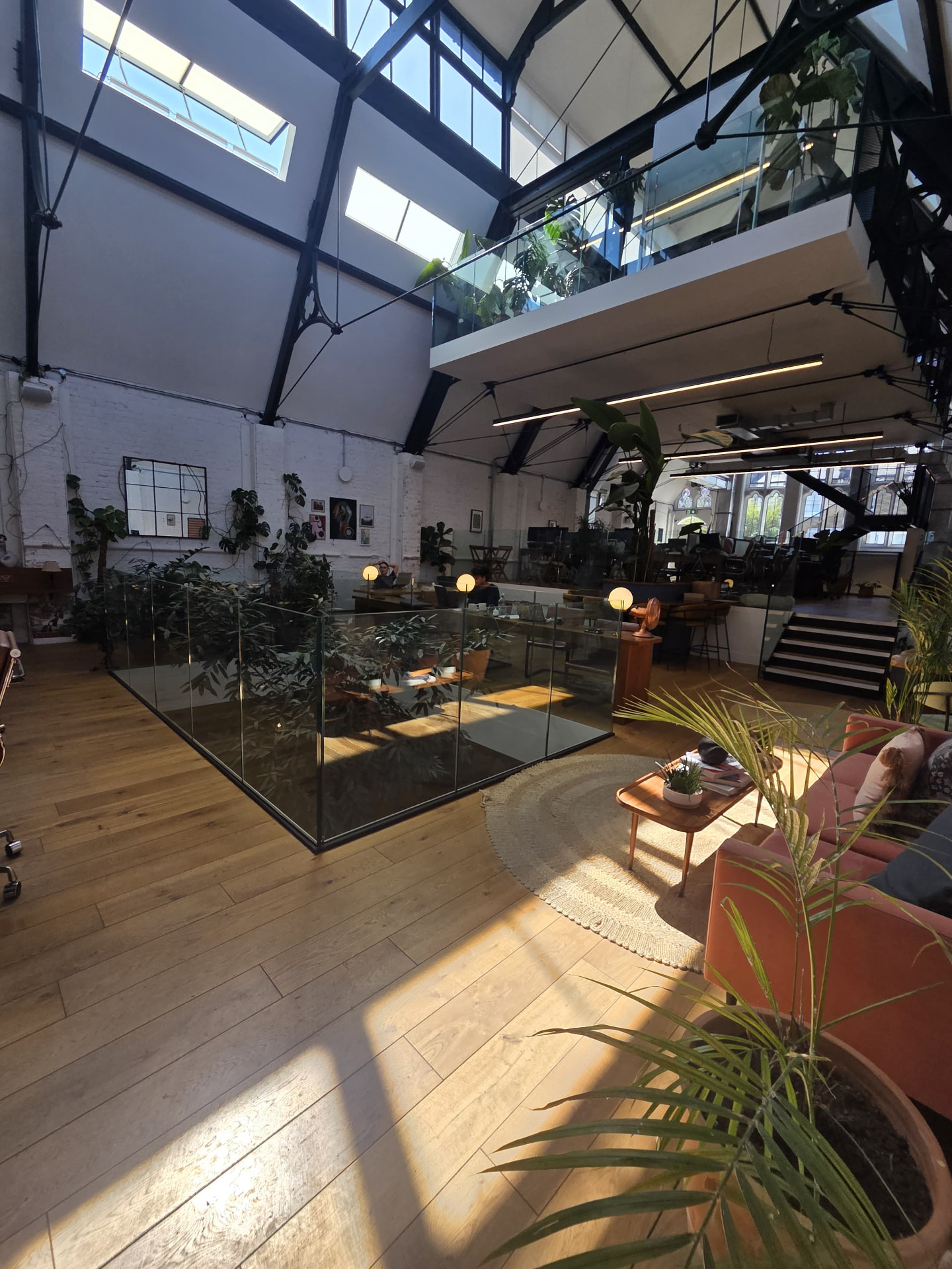 Open-plan office atrium with plants and skylights